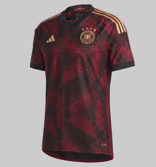 Jersey de visitante Adidas Alemania Authentic Match Mundial 2022 (HF1695), vista frontal completa con patrón negro y rojo y detalles dorados, disponible en Futbol90MX
