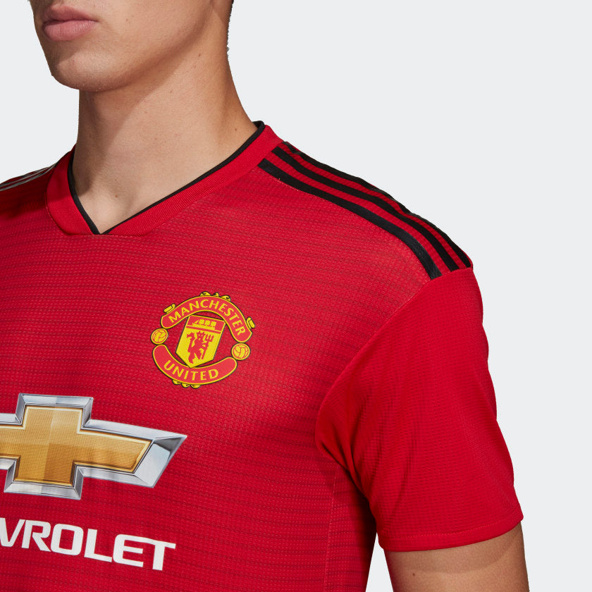 Primer plano del escudo del Manchester United en relieve de alta densidad, exclusivo de la versión de jugador Authentic.