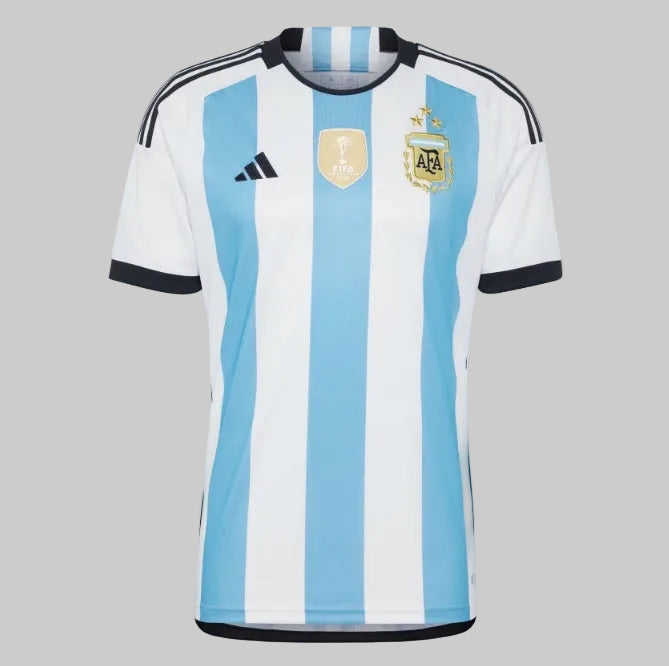 Vista frontal del jersey Adidas Argentina Campeon Mundial 2022, destacando la manga, el corte técnico y la integración de las franjas negras Adidas en los hombros.