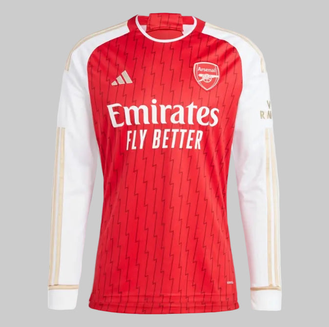 Vista detallada del tejido frontal que muestra el patrón gráfico sutil de rayos y la estructura textil de alto rendimiento del jersey manga larga 2023/24 del Arsenal, disponible en Futbol90X