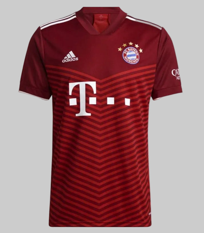 Vista frontal completa del jersey de local Adidas del FC Bayern München 2021/22 (modelo GM5313) sobre fondo blanco, mostrando la base en tonos burdeos y rojo, las tres franjas blancas en los hombros y el patrocinio de T-Mobile, en Futbol90MX