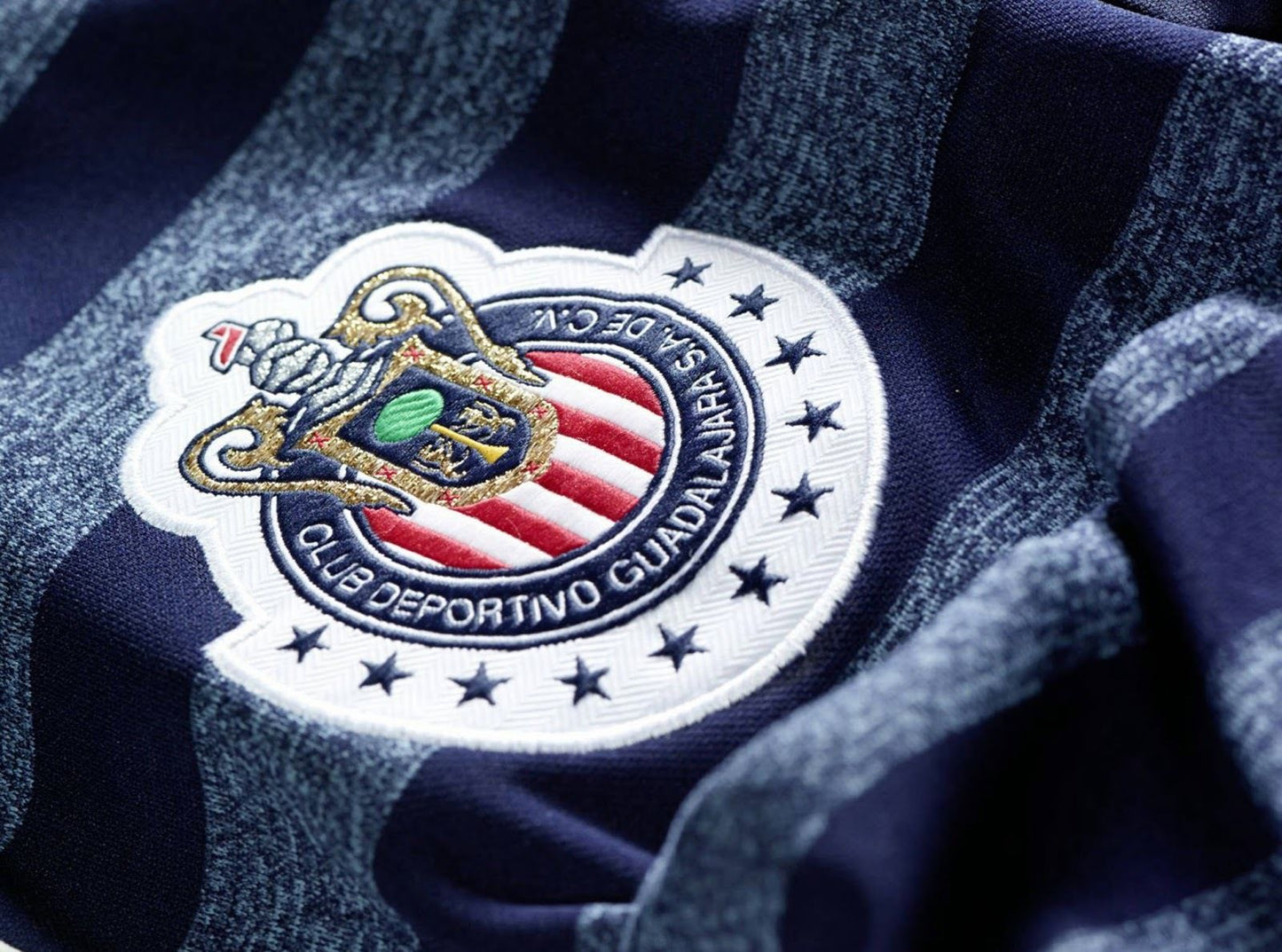 Detalle del escudo bordado de Chivas y el logo de Adidas en el pecho del jersey manga larga de visita 2014, mostrando la integridad del tejido y los emblemas, en Futbol90MX