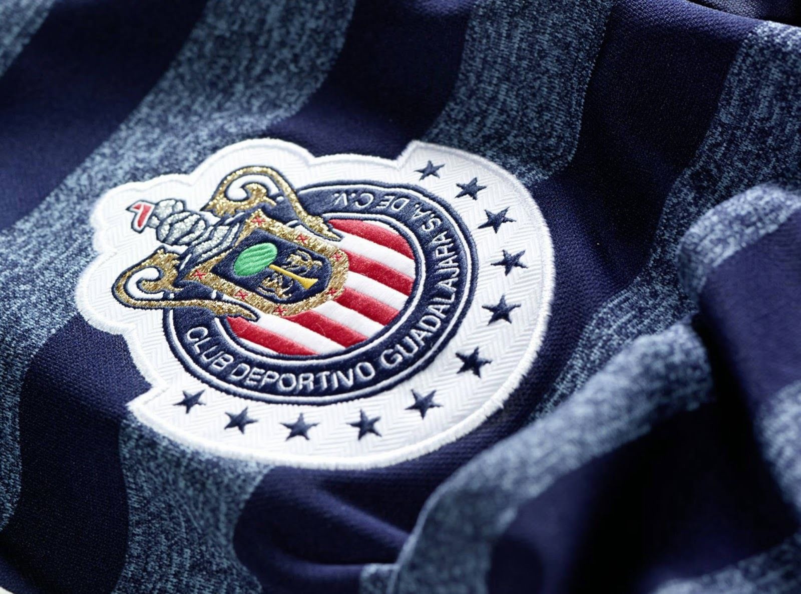 Detalle del escudo bordado de Chivas y el logo de Adidas en el pecho del jersey manga larga de visita 2014, mostrando la integridad del tejido y los emblemas, en Futbol90MX