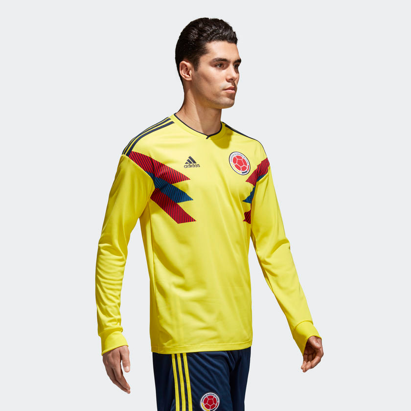 Ángulo lateral que resalta la elegancia de la configuración de manga larga y la vibrante identidad tricolor de la prenda adidas Colombia Jersey Manga Larga local Mundial 2018