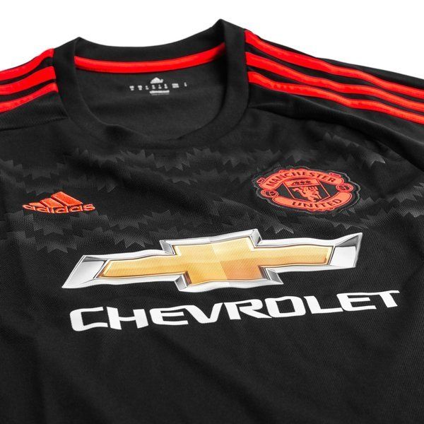 Primer plano del pecho del tercer jersey de Beckham del Manchester United 2015/16 (Ref. AC1445), mostrando el patrocinador central Chevrolet, el escudo monocromático en rojo solar, el logotipo de Adidas y el tramado gráfico geométrico sobre la base negra, en Futbol90MX