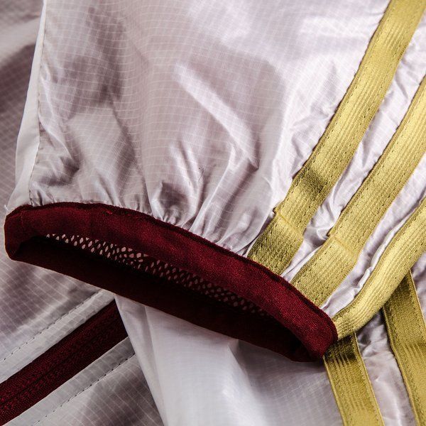 Detalle de las icónicas tres franjas de adidas en acabado dorado y el puño en tono borgoña de la chamarra anthem de España 2014 (Ref. D83723) en Futbol90MX