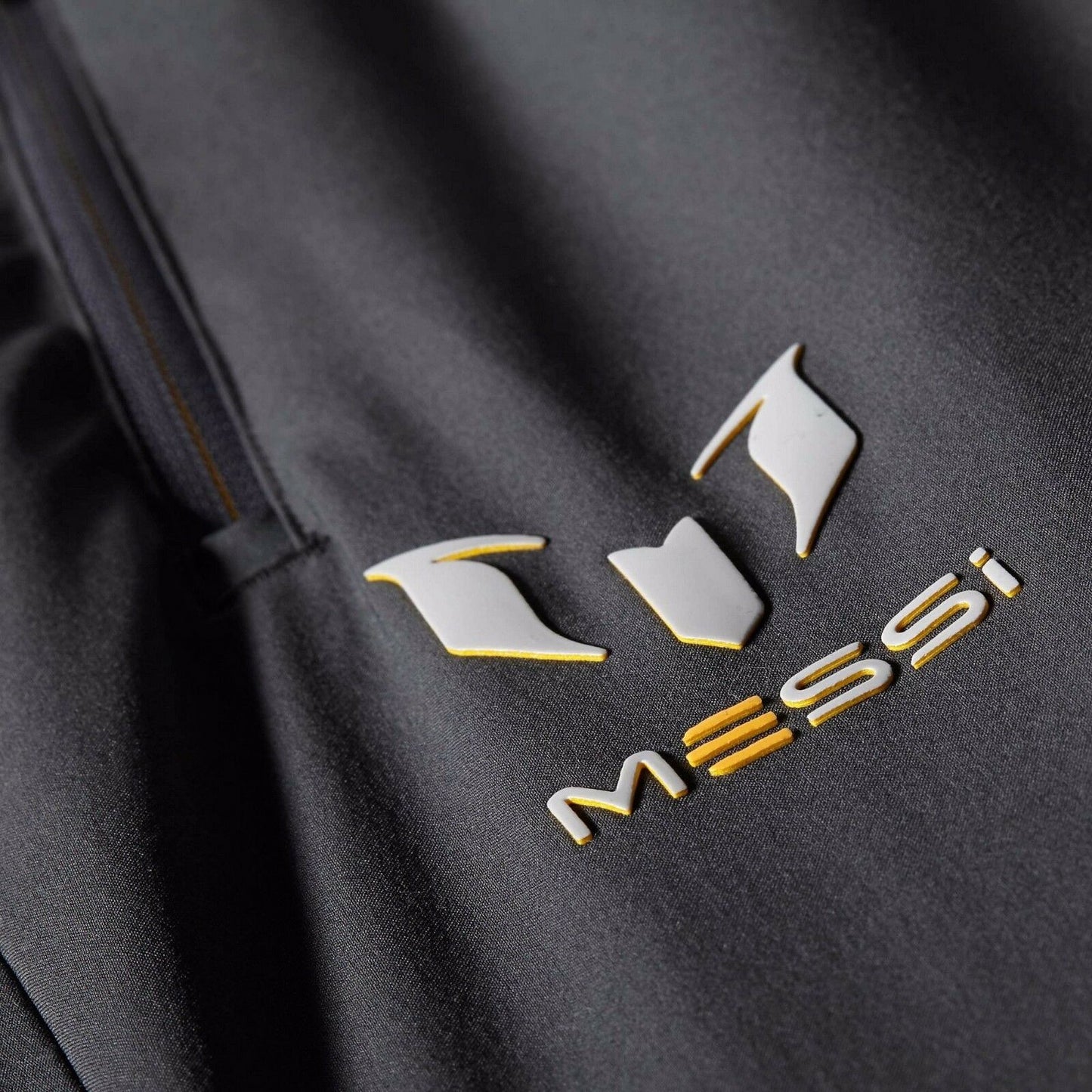 Primer plano del logotipo personal de Leo Messi termosellado en plata metálica sobre tejido técnico de pantalón Adidas F50 Futbol90MX