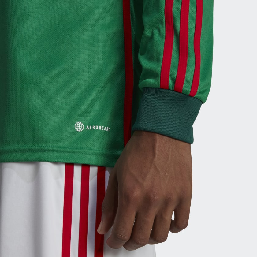 Acercamiento al puño acanalado con las 3 franjas en rojo y etiqueta AEROREADY en el Jersey Adidas de Mexico Manga Larga Mundial 2022 de Lozano, codigo HE8850