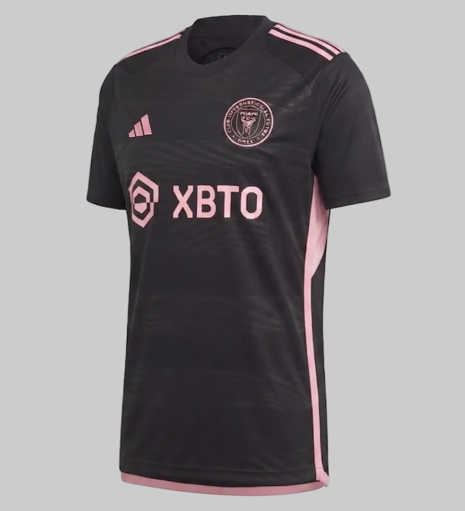 Vista angulada del jersey Inter Miami Visita 2023/24 (código HI1888), mostrando el escudo circular del club y el logo Adidas en rosa brillante sobre tejido técnico negro, disponible en Futbol90MX