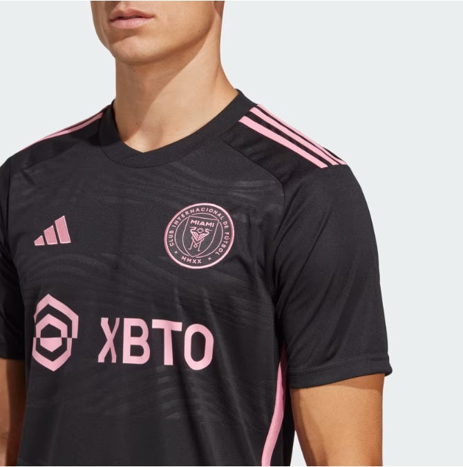 Primer plano del escudo del Inter Miami y el logo de Adidas en el jersey HI1888, enfatizando la calidad de las aplicaciones y la textura del tejido "La Noche".
