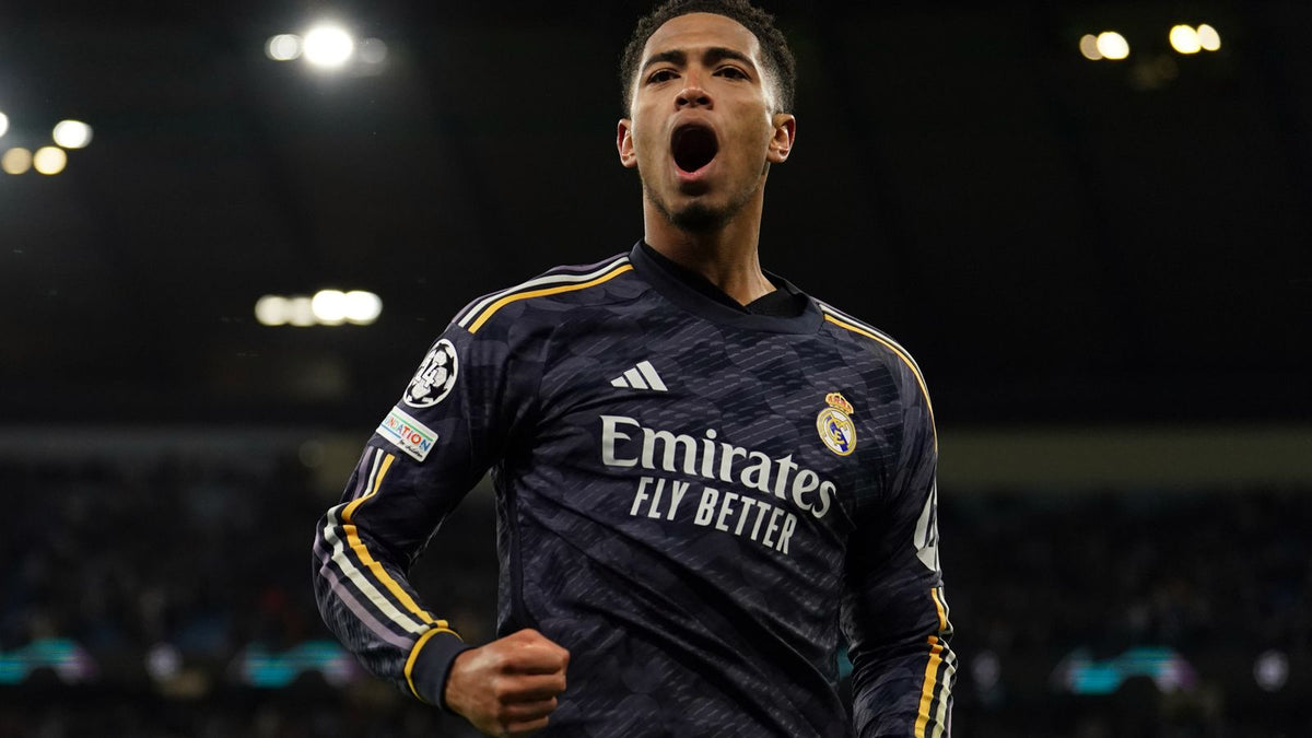 Fotografía de Jude Bellingham eufórico tras anotar en partido oficial de la UEFA Champions League portando el jersey visitante del Real Madrid 2023/24 en Futbol90MX