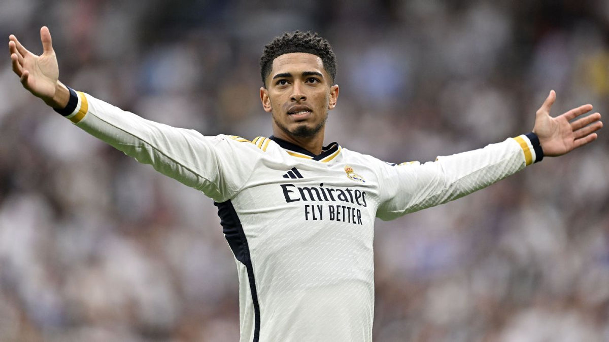 Jude Bellingham celebrando con los brazos abiertos luciendo el jersey Adidas Real Madrid de manga larga de casa UCL 2023/24 en Futbol90MX