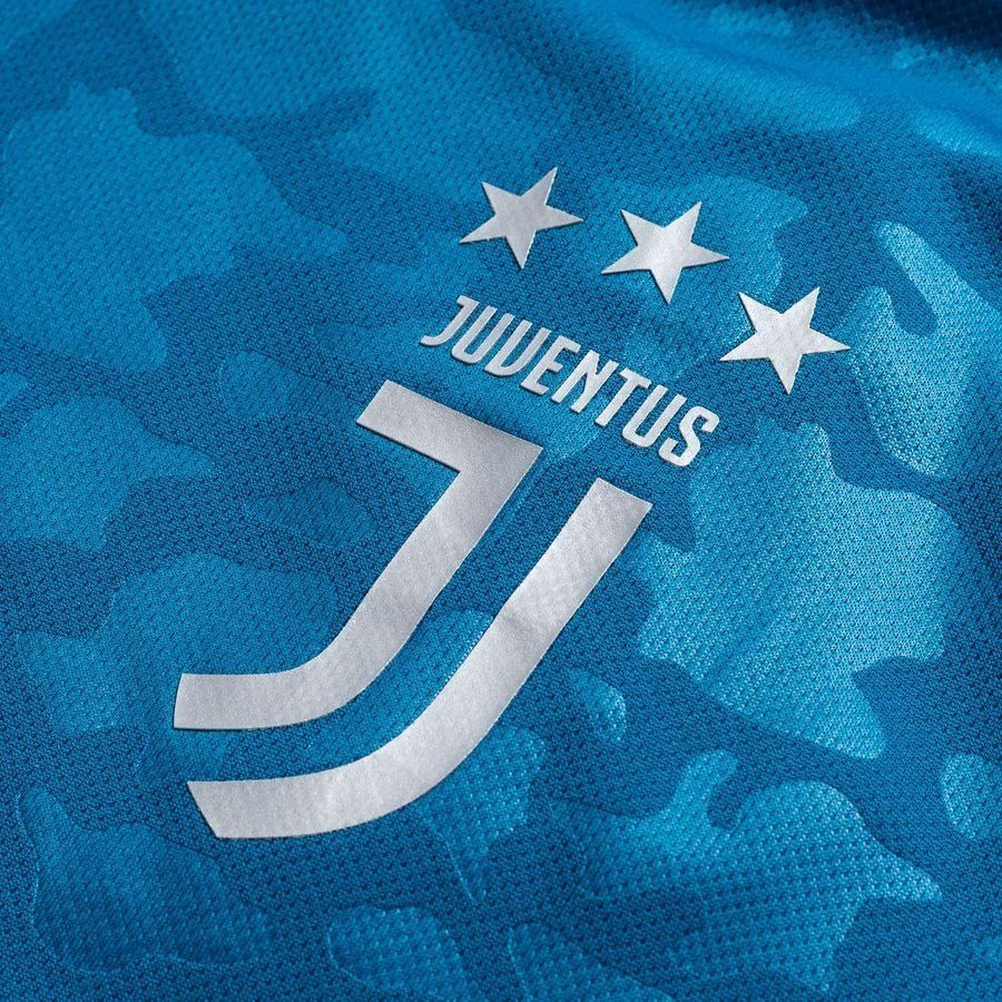 Primer plano del escudo oficial termo aplicado de la Juventus en color plateado sobre el tejido con patrón de camuflaje azul del tercer jersey 2019/20 (DW5471) de Futbol90MX