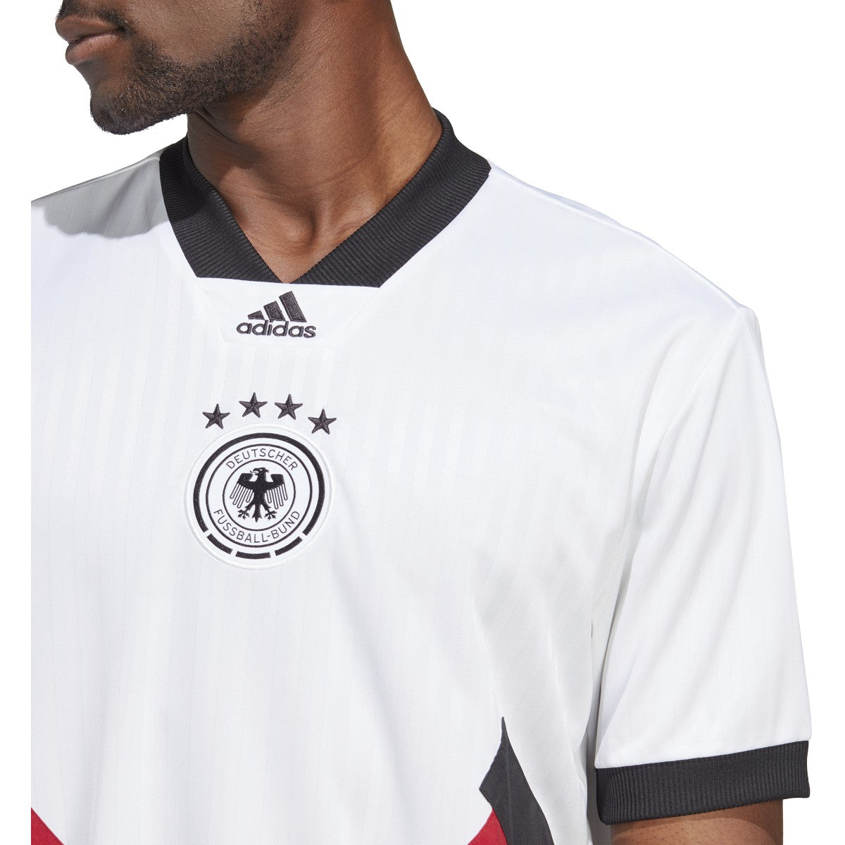 Escudo de la Federación Alemana de Fútbol (DFB) bordado con cuatro estrellas y logotipo de adidas centrado. Textura de alta densidad sobre base blanca técnica.