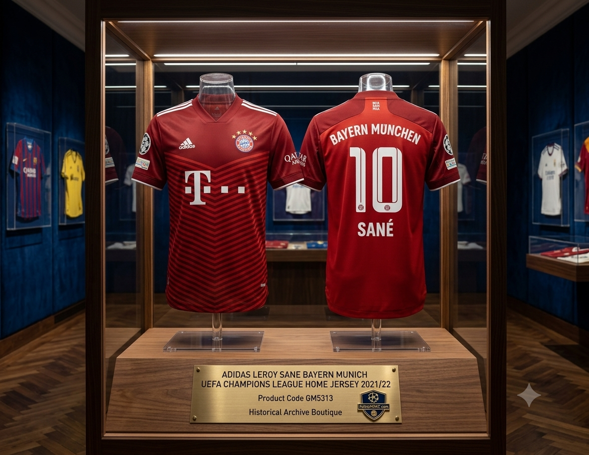 Vista con calidad de museo de una vitrina de archivo iluminada con LED en un entorno sobrio, que exhibe conjuntamente el frente y el reverso del jersey Adidas del FC Bayern München UCL 2021/22 de Leroy Sané #10 sobre bases estilizadas, codigo GM5313, con una placa descriptiva de la colección en la parte inferior, en Historical Archive Boutique Futbol90MX