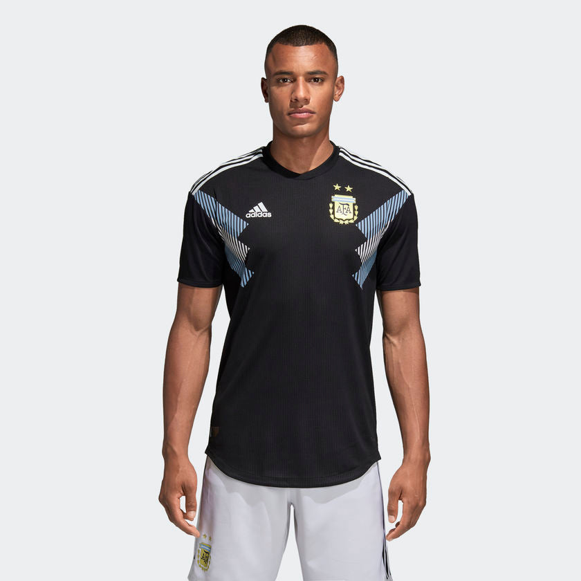 Vista detallada del panel de hombros con las tres franjas icónicas de Adidas y el patrón gráfico de líneas de velocidad característico del modelo away 2018.
