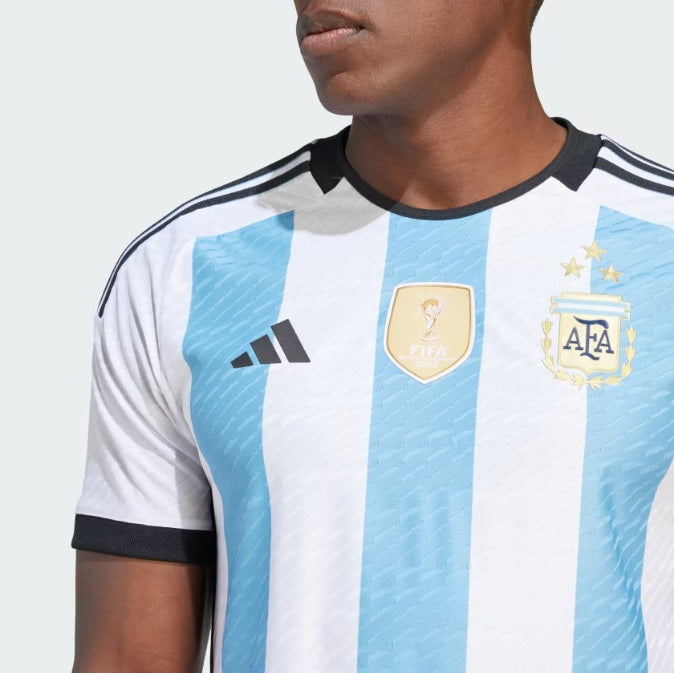 Detalle en primer plano del escudo de la AFA bordado en relieve con las tres estrellas doradas y parche oficial de FIFA World Champions 2022 en el jersey Authentic Match de Argentina de Messi, en Futbol90MX