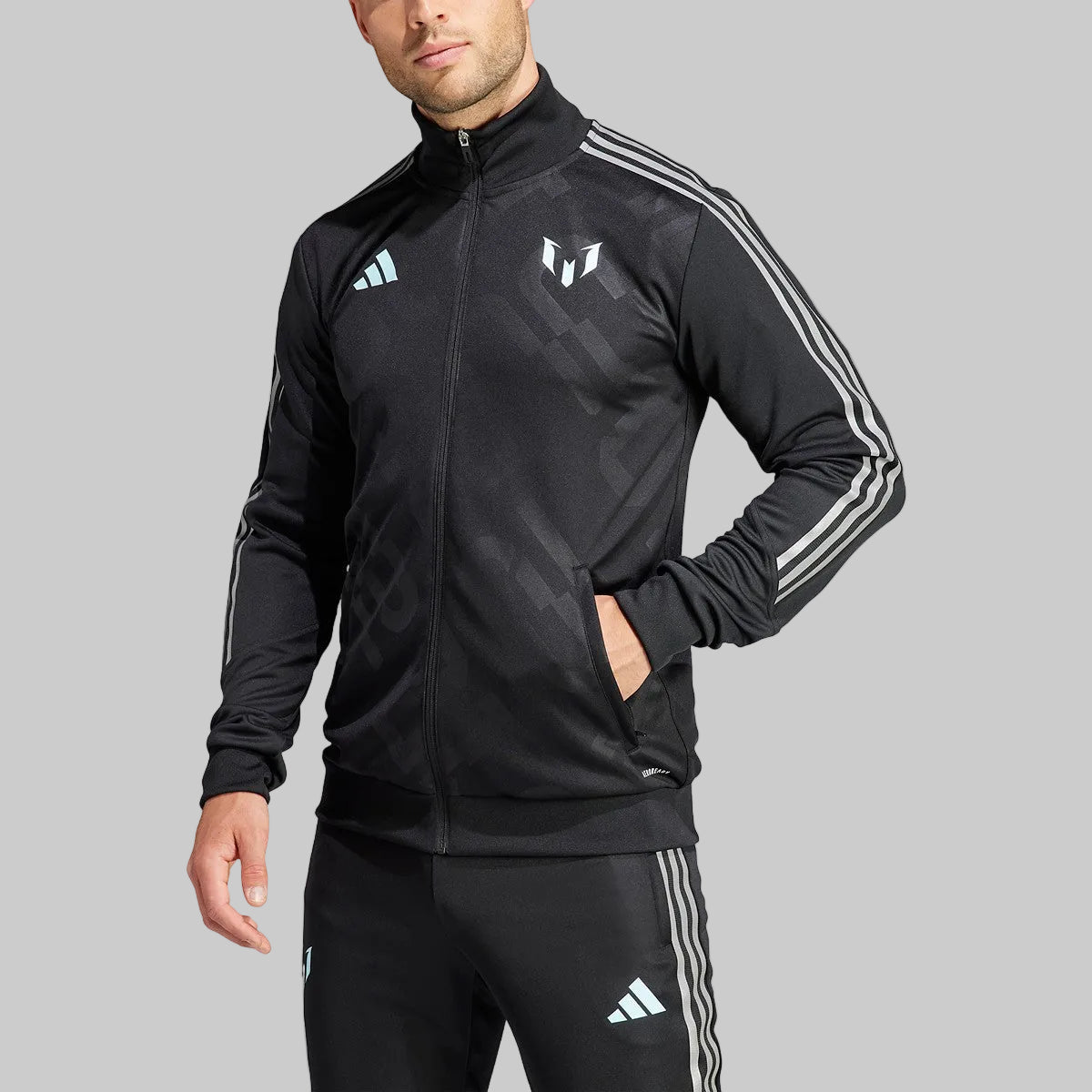 Vista de medio cuerpo de un modelo portando la chamarra de entrenamiento adidas Lionel Messi 2023 (Ref. IJ4936), destacando el cierre frontal y los bolsillos laterales, stock Futbol90MX
