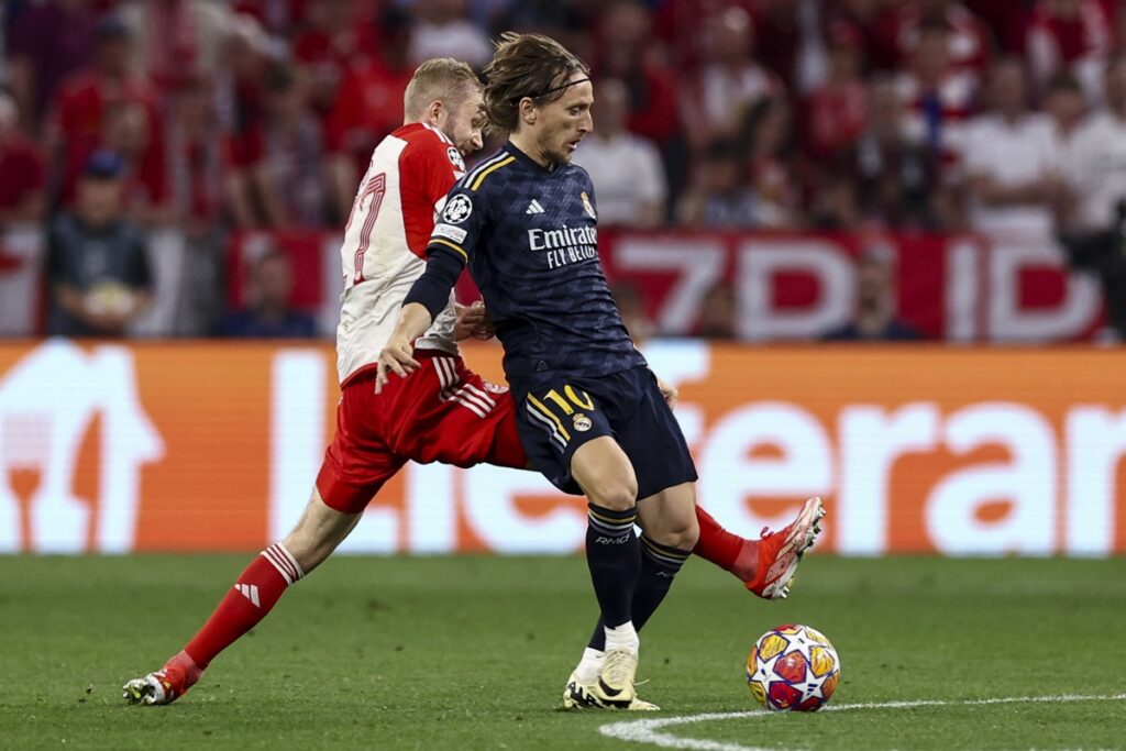 Fotografía de acción de Luka Modrić controlando el balón en partido de UEFA Champions League vistiendo la indumentaria visitante del Real Madrid en Futbol90MX