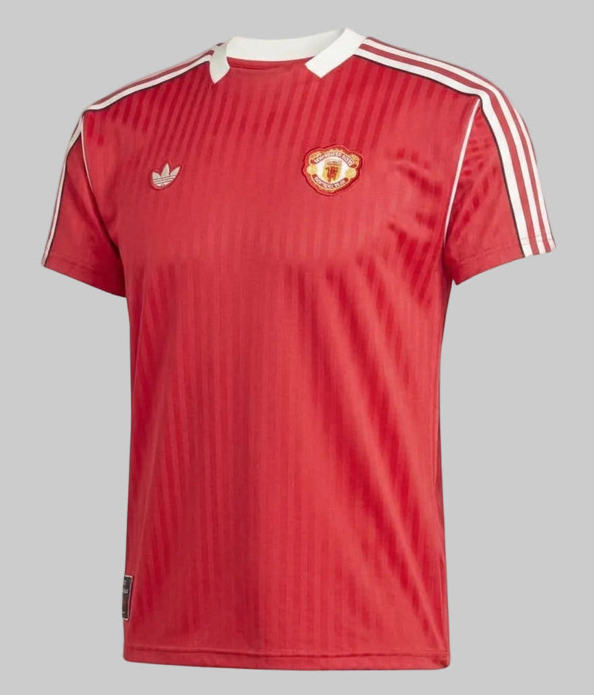Vista frontal ligeramente angulada del jersey Adidas Manchester United Icon (Ref. JF0386) en color rojo histórico con rayas verticales tonales y detalles en blanco, disponible en la Historical Archive Boutique de Futbol90MX
