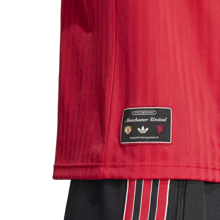 Detalle de la etiqueta de autenticidad de la colección Icon situada en el dobladillo inferior del jersey Adidas Manchester United (Ref. JF0386) en Futbol90MX