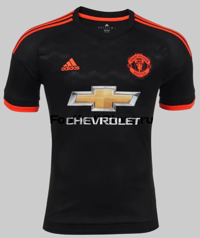 Primer plano de alta definición del pecho del tercer jersey del Manchester United 2015/16 (Ref. AC1445), resaltando el escudo monocromático del club y el logotipo 3-Bar de Adidas en tono rojo solar, en Futbol90MX