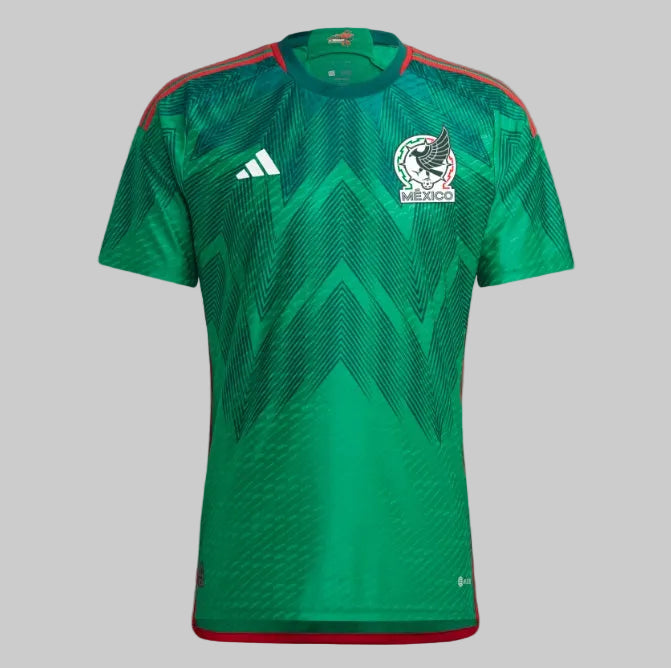 Primer plano del patrón gráfico integral inspirado en Quetzalcóatl sobre el tejido verde del jersey adidas Authentic Match de México Mundial 2022, codigo HD6898, en Futbol90MX