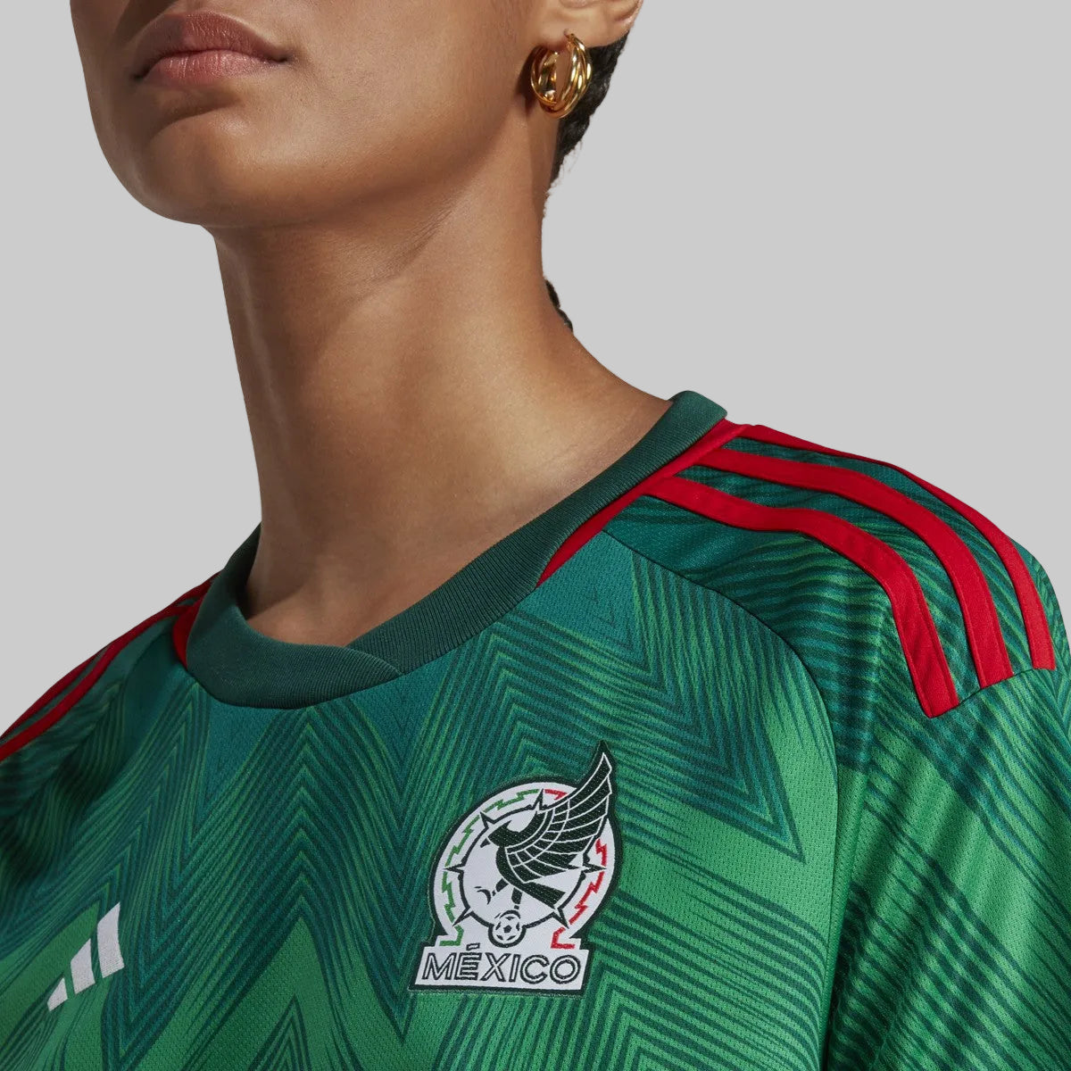 Close-up del escudo de la Selección Nacional de México en el jersey de casa 2022. Bordado de alta densidad y textura técnica preservada. Calidad de archivo histórico Futbol90MX