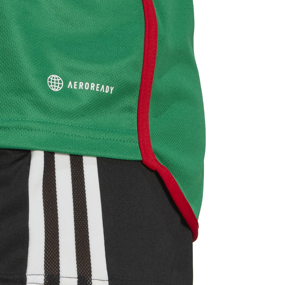 "Primer plano del tejido AEROREADY en el jersey México 2022. Trama microperforada para ventilación y patrón geométrico inspirado en el Quetzal. Activo verificado.