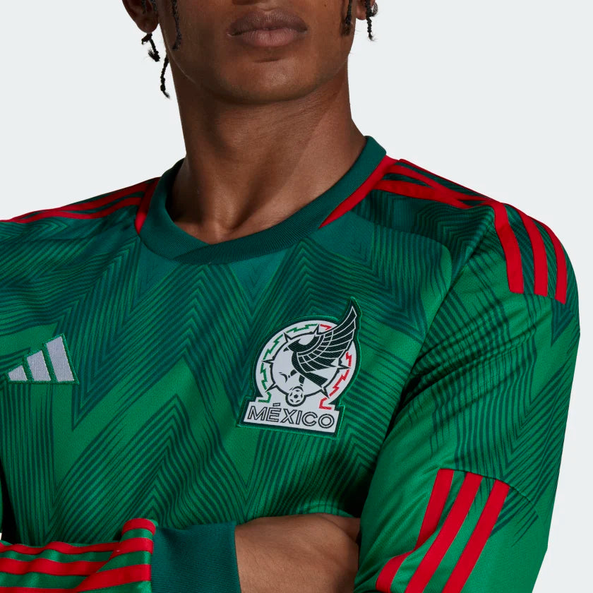 Detalle en alta definición del nuevo escudo bordado de la Selección Mexicana de Fútbol y el logotipo blanco de Adidas en el pecho del jersey de manga larga de la Copa del Mundo 2022 en Futbol90MX