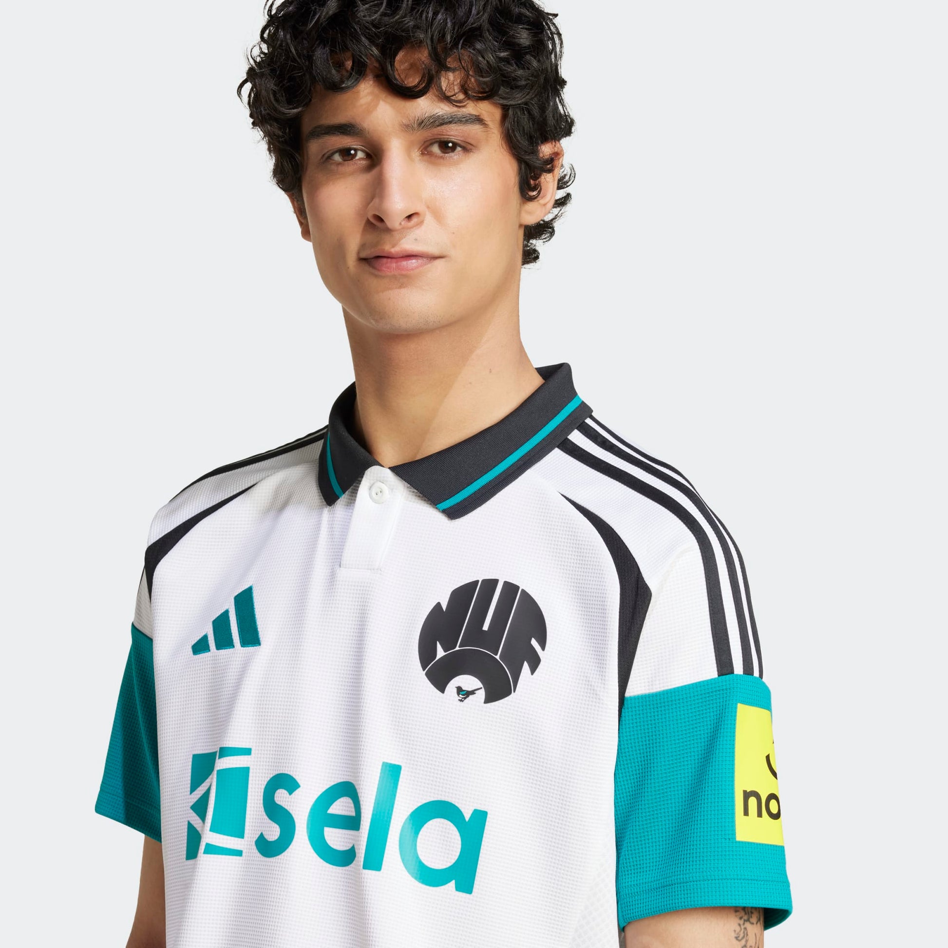 Detalle del escudo retro de las Magpies y logotipo de Adidas bordado en el jersey de visita Newcastle 2024/25, estilo vintage de archivo.
