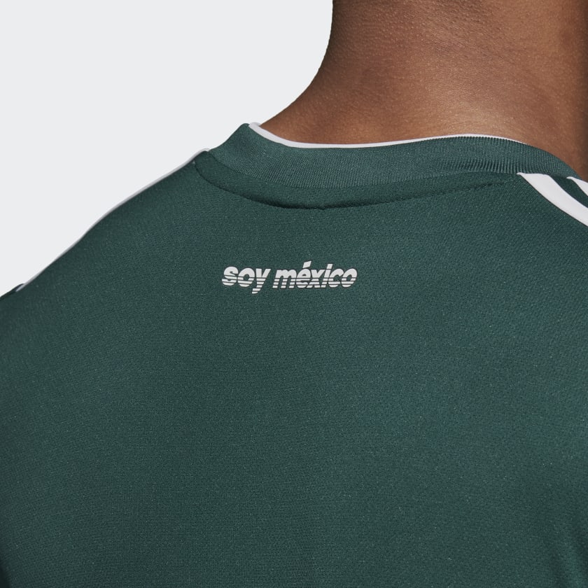 Vista del cuello en V blanco acanalado y el gráfico de identidad "Soy México" transferido térmicamente en la parte posterior del cuello del jersey nacional de Rafael Marquez