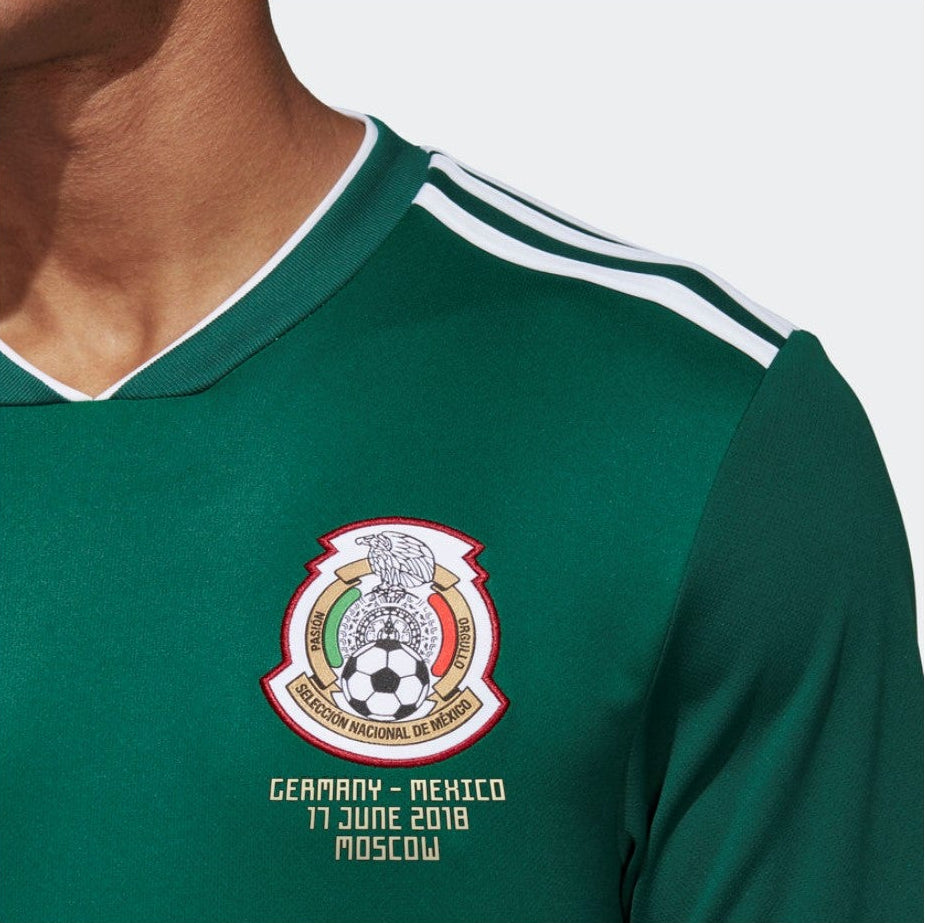 Acercamiento a la leyenda de partido "GERMANY VS. MEXICO – 17 JUNE 2018 – MOSCOW" termo-sellada con alta precisión bajo el escudo de la Selección Mexicana en Jersey adidas BQ4700 Mexico Manga Larga Mundial 2018 Rafael Marquez