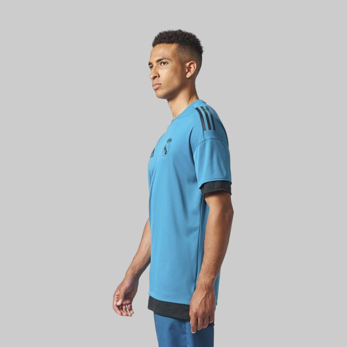 Vista lateral del hombro y la manga de la playera Adidas Real Madrid 2017/18 (BQ7840), resaltando las emblemáticas franjas de la marca y las costuras ergonómicas, disponible en Futbol90MX