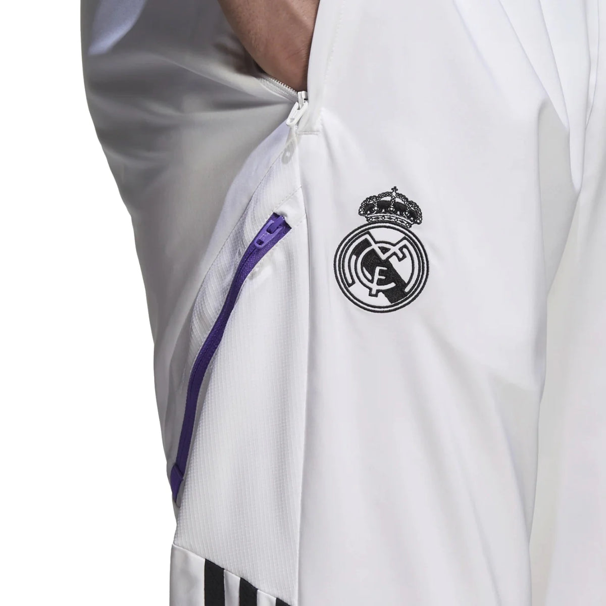 Primer plano del escudo del Real Madrid y el bolsillo con cierre en los pantalones de presentación Adidas 2022/23 (Ref. HA2592) en la Historical Archive Boutique de Futbol90MX.