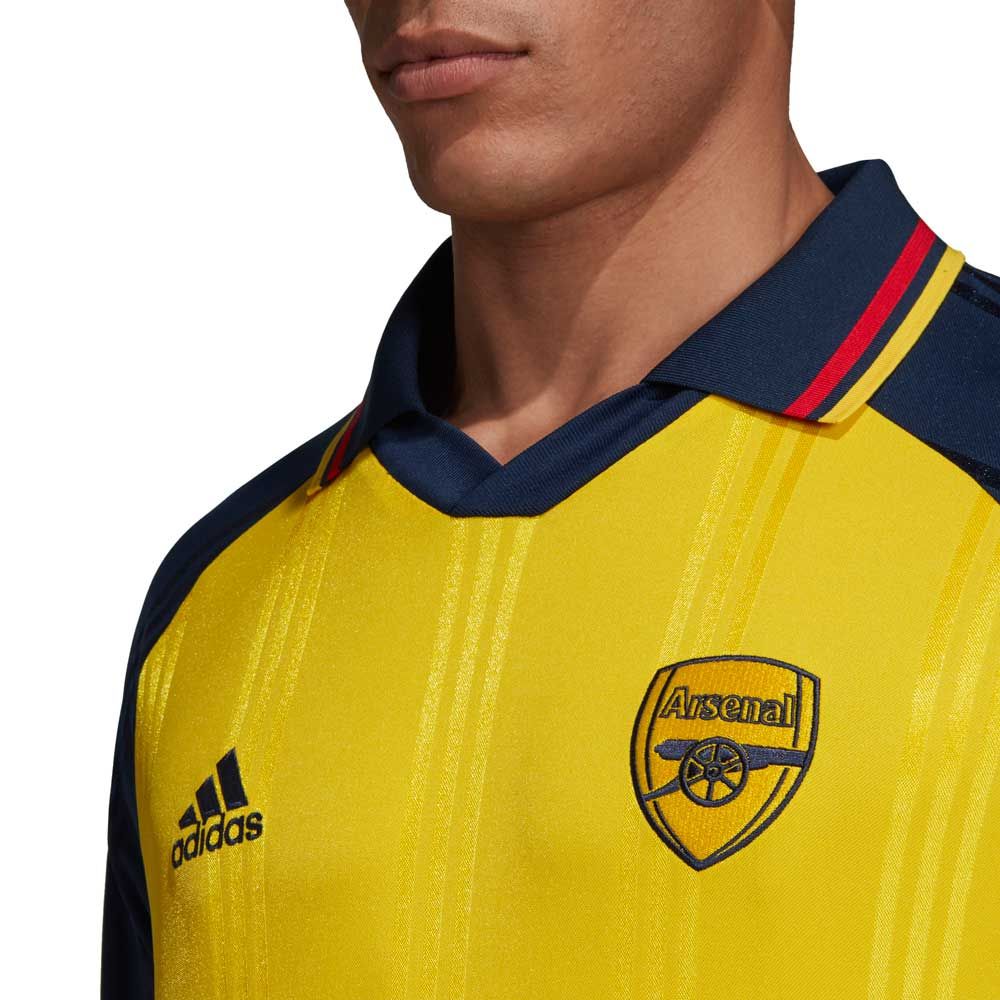 Detalle en primer plano del escudo del Arsenal FC y adidas logo bordados con precisión en el pecho del jersey retro Icons de Thierry Henry