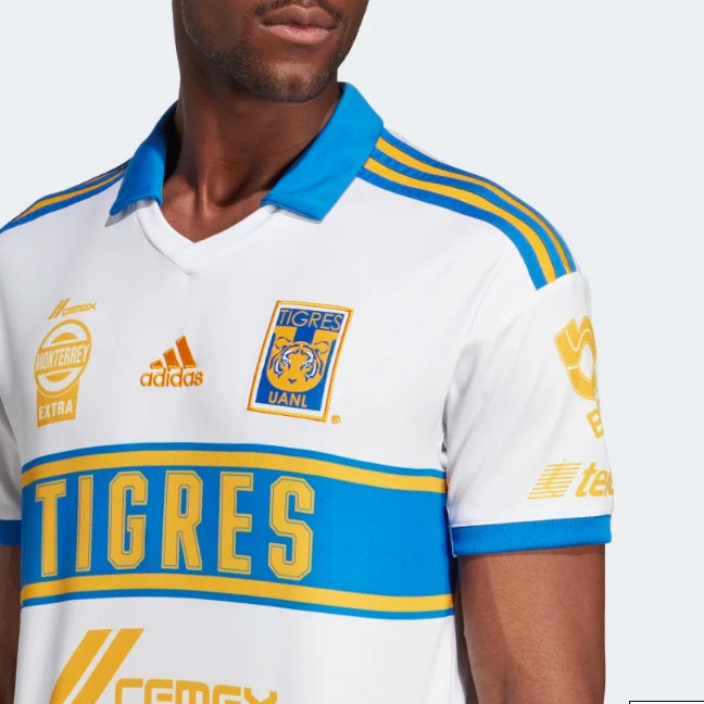Primer plano del escudo bordado del Club Tigres UANL y logotipo de Adidas en alta densidad. Verificación técnica de autenticidad para coleccionistas.