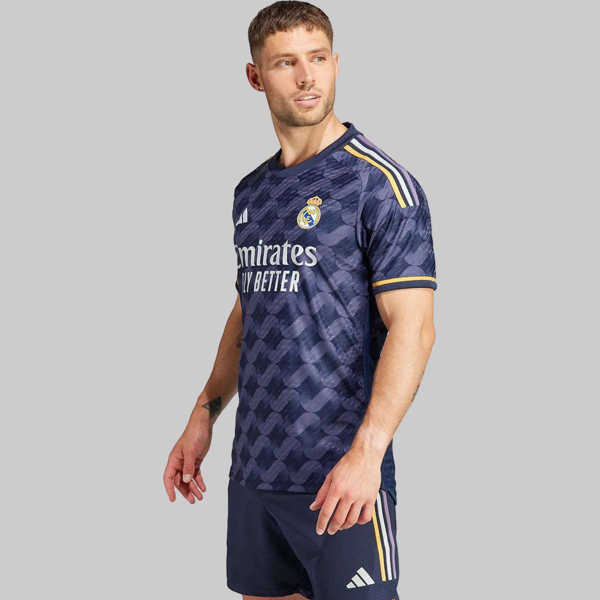 Vista tres cuartos de modelo luciendo el jersey Adidas Vini Jr Real Madrid Authentic Match visitante UEFA Champions League 2023/24 (Ref. IA5138) y short oficial en tono azul noche en Futbol90MX