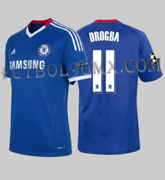 Vista dual del jersey Adidas de local Chelsea FC UEFA Champions League 2010/11 con la personalización oficial "DROGBA" y número "11" en blanco, incluyendo detalles técnicos de alta calidad, codigo P95900, disponible en Futbol90MX