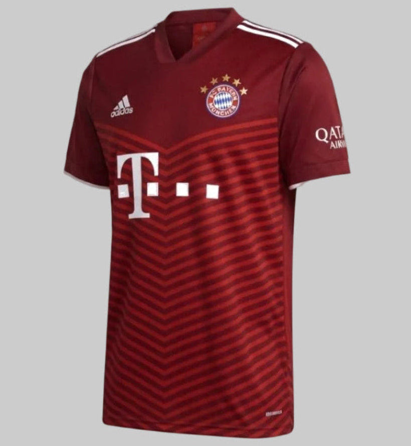 Vista en ángulo de tres cuartos frontal del jersey de local Adidas del FC Bayern München 2021/22, destacando la estructura del cuello en V, el escudo con las cinco estrellas doradas y el diseño de chevrones en el torso, codigo GM5313, disponible en Futbol90MX
