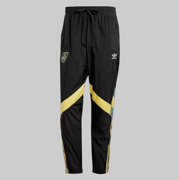 Pants de entrenamiento Adidas Originals Jamaica 2024 IN5570 en color negro con diseño de bloques asimétricos en amarillo y verde.
