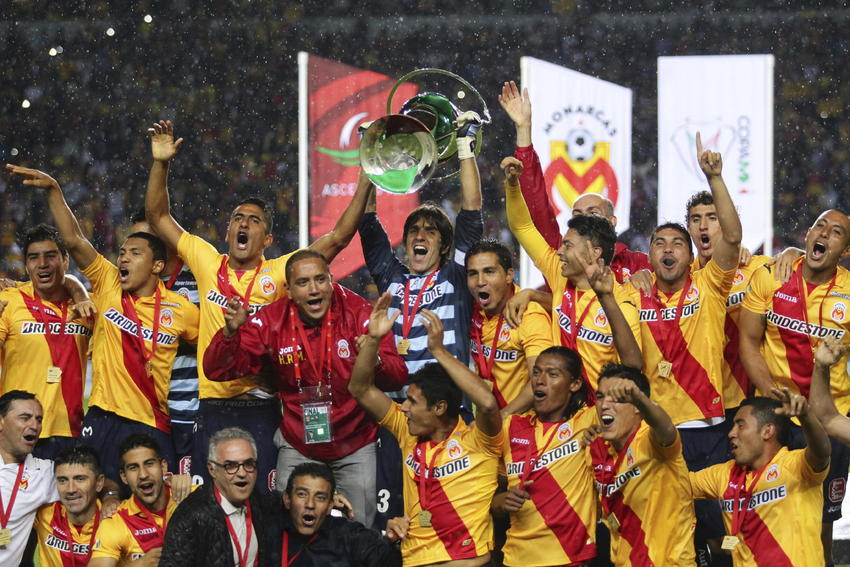 Plantel de Monarcas Morelia celebrando la conquista del título de la Copa MX Apertura 2013 en el Estadio Morelos vistiendo el jersey Joma de la franja roja (Ref. MM101011-13) en Futbol90MX