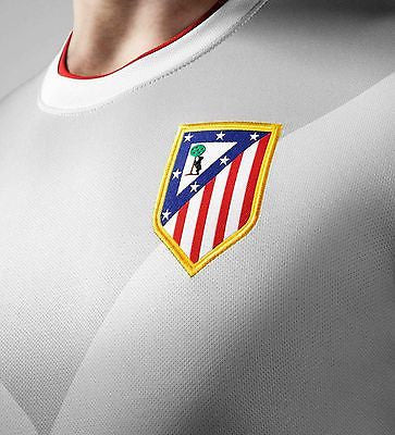 Detalle del escudo del club tejido y cuello redondo acanalado con el tricolor de la bandera española en el jersey Nike de visita del Atlético de Madrid 2014, stock Futbol90MX