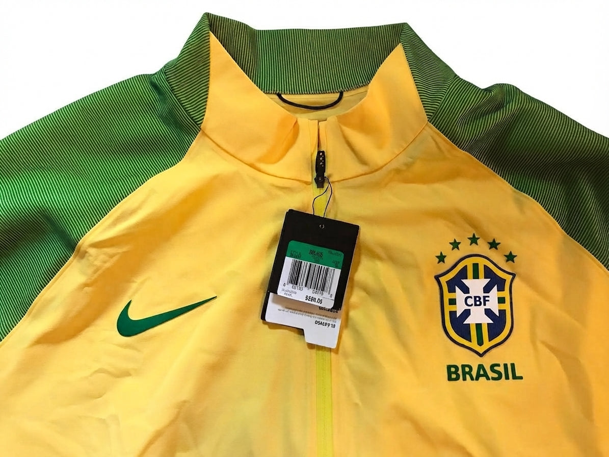 Primer plano del cuello alto, el logotipo Nike Swoosh, la etiqueta de autenticidad colgante y el escudo de la CBF en la chamarra Nike Brasil Elite Revolution 2016 (Ref. 802447-703) en Futbol90MX