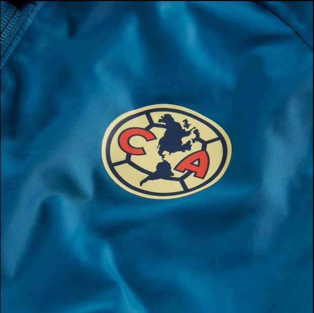 Primer plano del escudo institucional del Club América en la chamarra Academy AWF 2020/21 (Ref. CI9513-457) en Futbol90MX