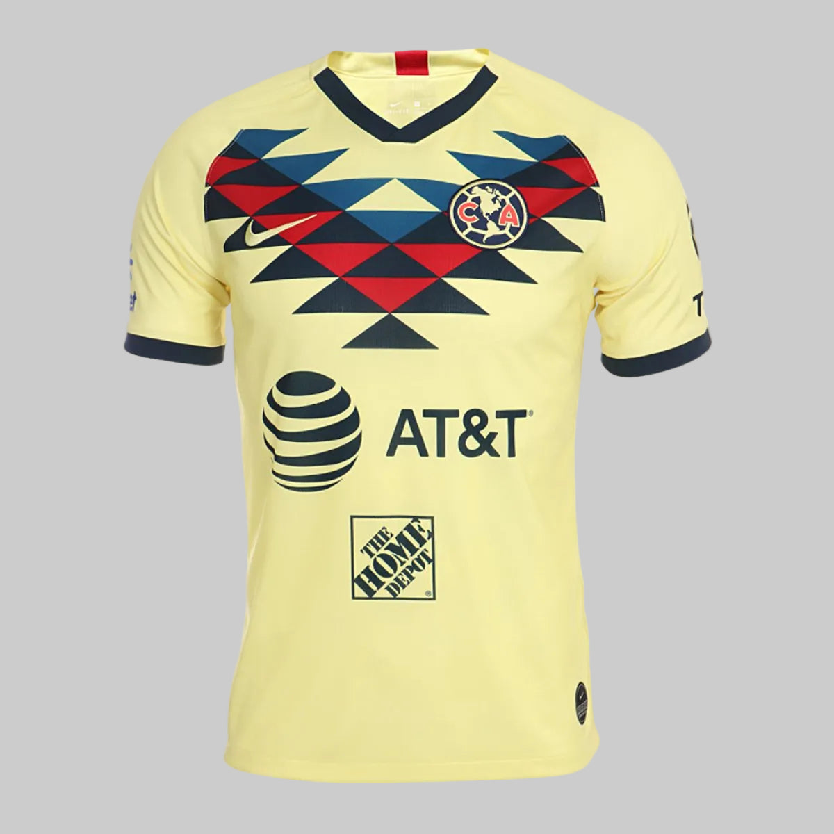 Primer plano frontal del escudo de las Águilas del América y el patrón geométrico azteca en tonos azul, rojo y amarillo del jersey Nike Club América 2019/20 (Art. AJ5527-707), en Futbol90MX