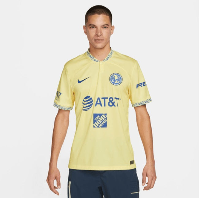 Vista frontal del jersey de local Club América 22/23 mostrando el escudo centralizado y patrocinadores AT&T y Home Depot integrados al diseño.