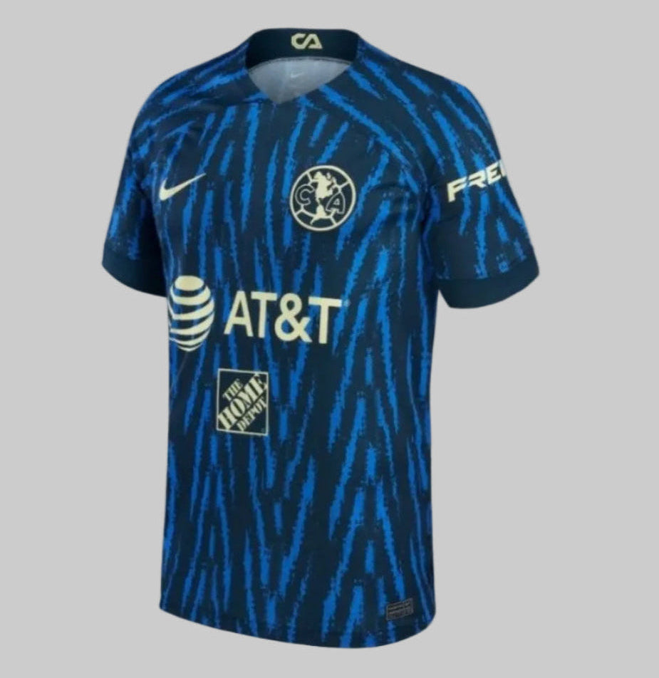 Vista lateral izquierda del jersey de visitante Club América 2022/23 con diseño 'Oceanic Glitch' en azul obsidiana y escudo centralizado Nike DJ7672-455