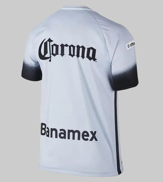 Vista posterior completa del tercer jersey Nike del Club América 2016 (código 709526-469), mostrando el diseño limpio en tono azul claro y el corte clásico de la prenda, stock Futbol90MX