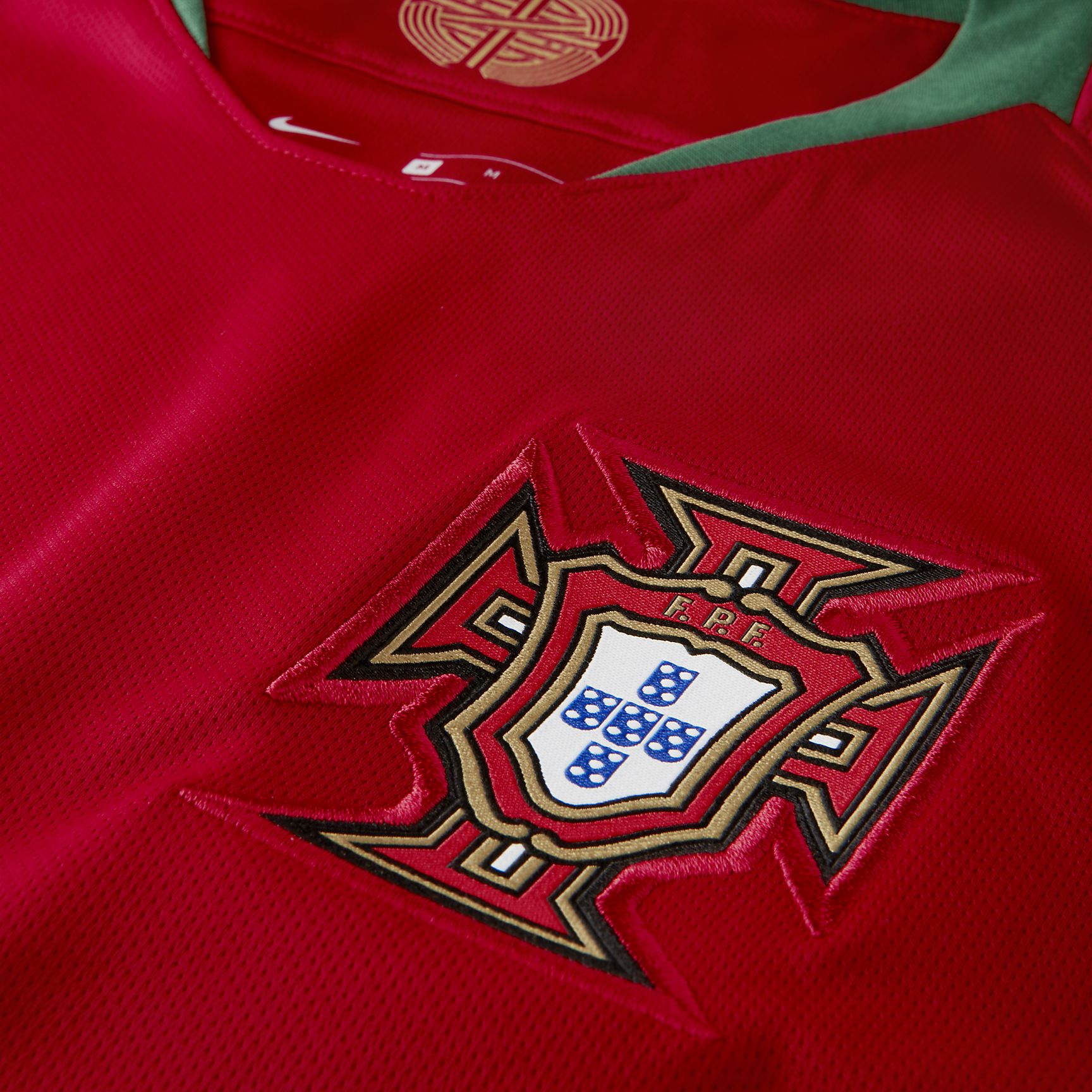 Escudo de la Federación Portuguesa de Fútbol bordado y detalle verde en el cuello que rinde homenaje a la bandera nacional en el jersey de CR7